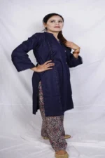 Woman posing with hand on hip in a navy blue kurta with lace sleeves, paired with a red, orange, and white patterned salwar