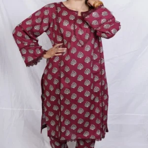 Woman adjusting hair in a maroon kurta design for women with white print and lace, paired with matching salwar.